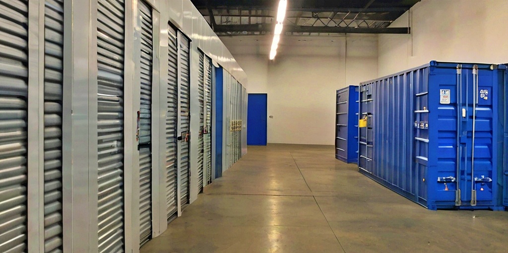 Möbellager mit Rolltoren und blauen Containern in einem modernen Lagerraum, geeignet für temporäre und langfristige Möbelaufbewahrung.