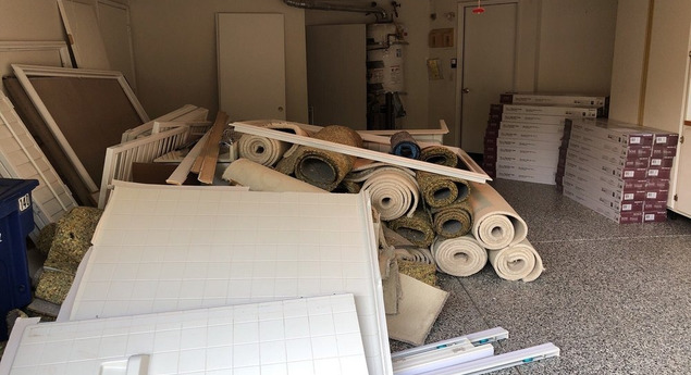 Überfüllter Raum mit Teppichrollen, Platten und Abfallmaterialien, ideal für Entrümpelung und Entsorgung durch Umzugsfirma Zürich.